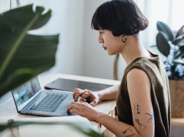 focused female working on laptop in house at table side hustles for students side hustle in kenya