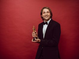 a proud actor holding his trophy